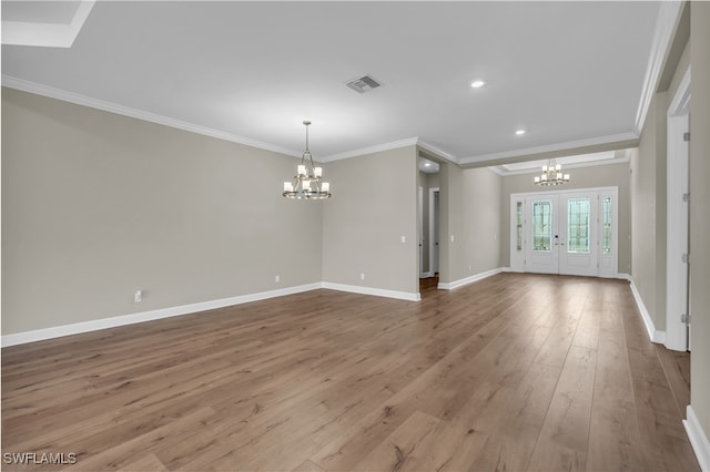 unfurnished living room with a chandelier, french doors, light hardwood / wood-style floors, and crown molding