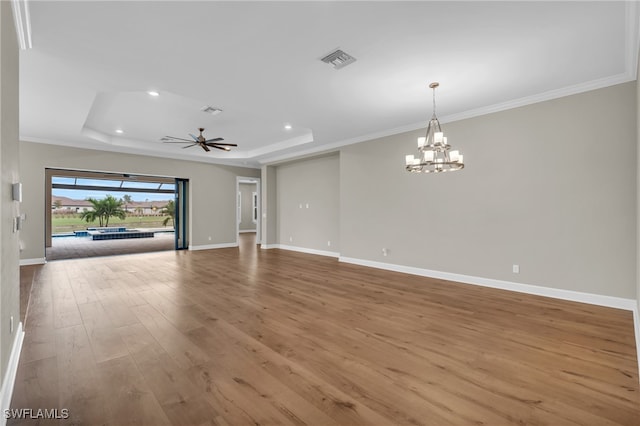 unfurnished living room featuring hardwood / wood-style floors, crown molding, and a tray ceiling