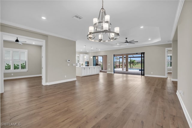 unfurnished living room featuring hardwood / wood-style flooring, ceiling fan with notable chandelier, and ornamental molding