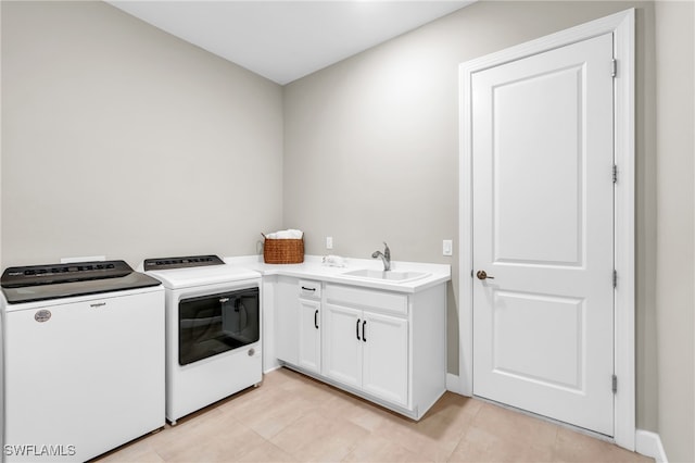 laundry area with washing machine and clothes dryer, sink, and cabinets