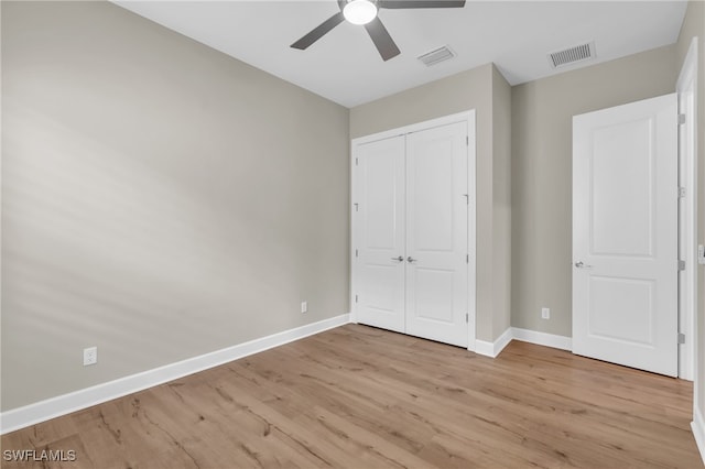 unfurnished bedroom featuring a closet, light hardwood / wood-style floors, and ceiling fan