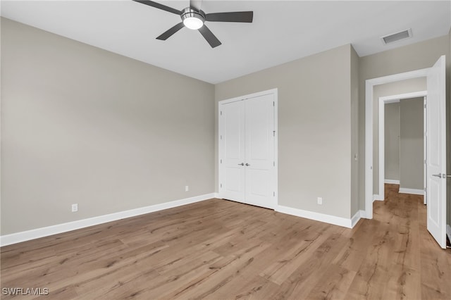 unfurnished bedroom with a closet, light hardwood / wood-style floors, and ceiling fan