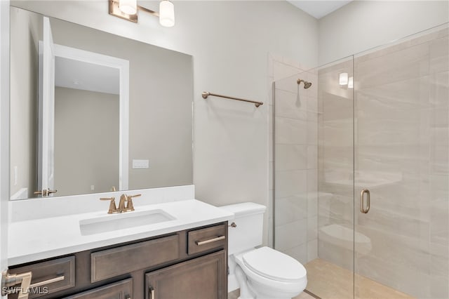 bathroom featuring vanity, toilet, and walk in shower