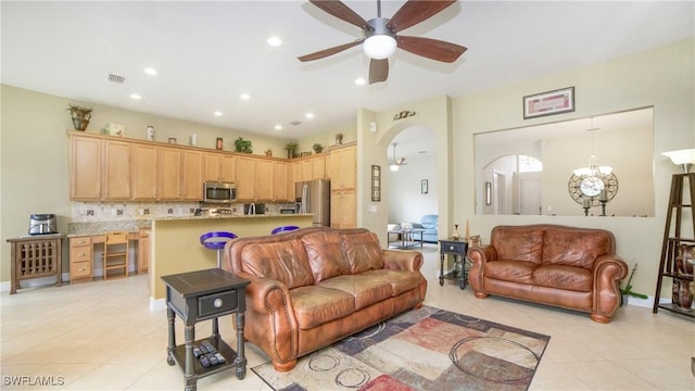 tiled living room featuring ceiling fan with notable chandelier