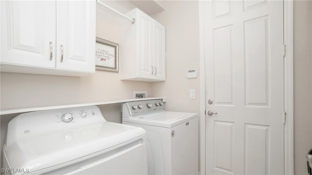 laundry room featuring cabinets and washing machine and dryer