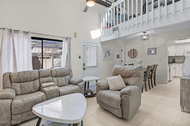 tiled living room featuring ceiling fan and a high ceiling