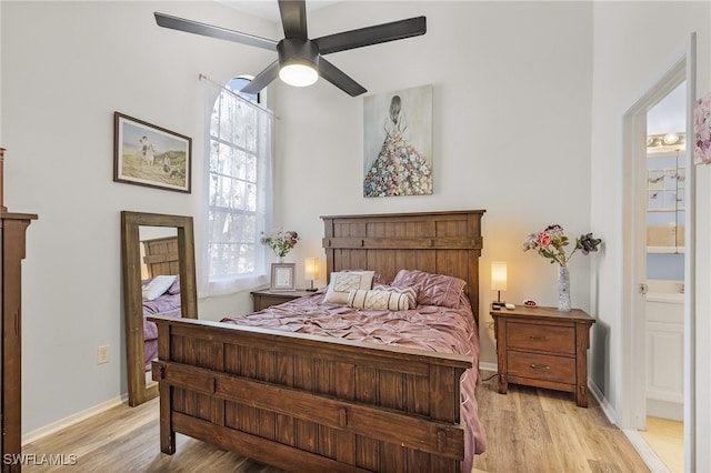 bedroom with light hardwood / wood-style floors, ceiling fan, and connected bathroom