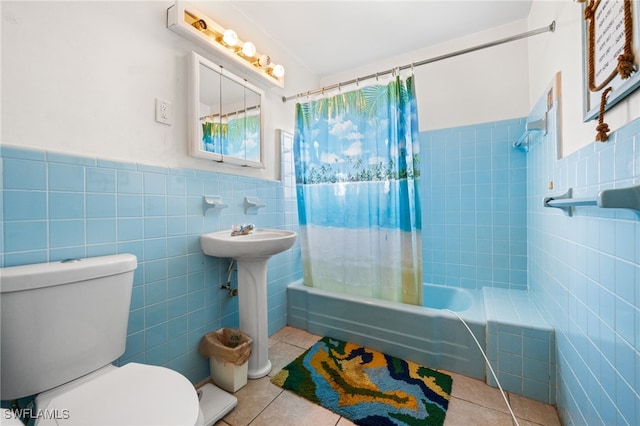 full bathroom with sink, tile patterned floors, shower / bath combination with curtain, toilet, and tile walls