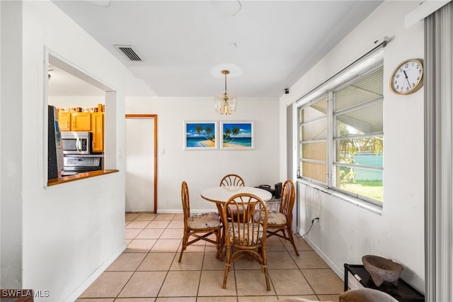 dining room with light tile patterned floors and an inviting chandelier