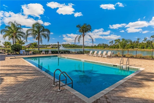 view of pool with a patio and a water view