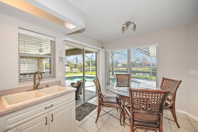 dining room featuring sink and light tile patterned floors