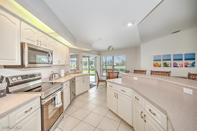 kitchen featuring white cabinets, appliances with stainless steel finishes, and light tile patterned floors