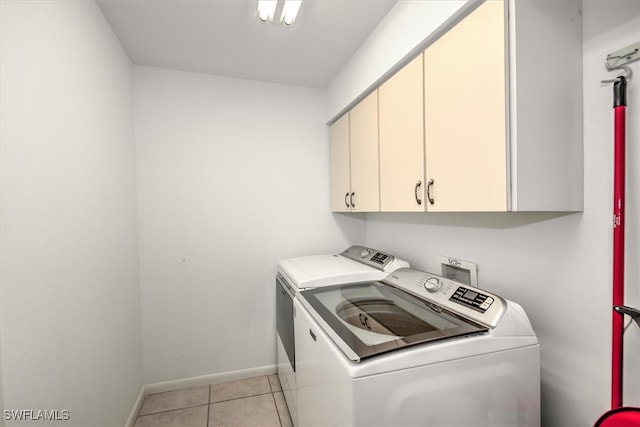 laundry area featuring cabinets, washer and dryer, and light tile patterned flooring