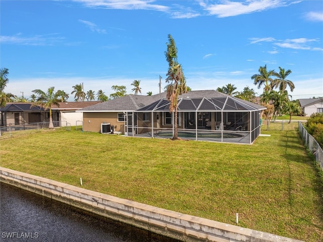 back of house with a swimming pool, a water view, a lanai, and a lawn