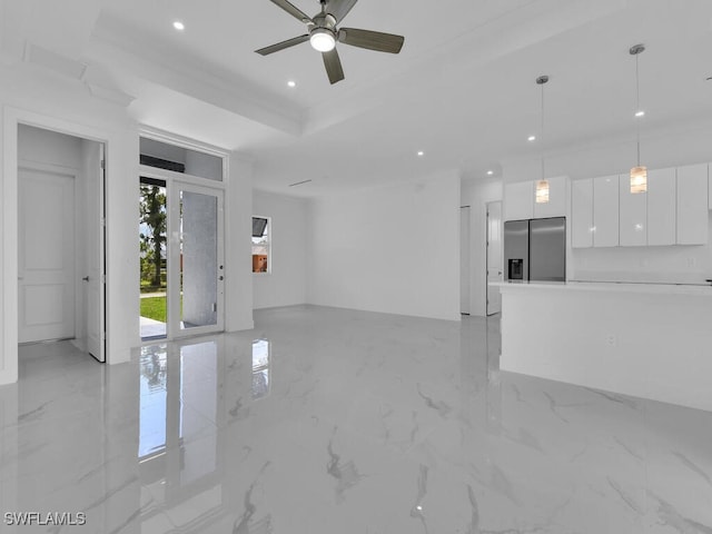 unfurnished living room featuring ceiling fan, crown molding, and a tray ceiling