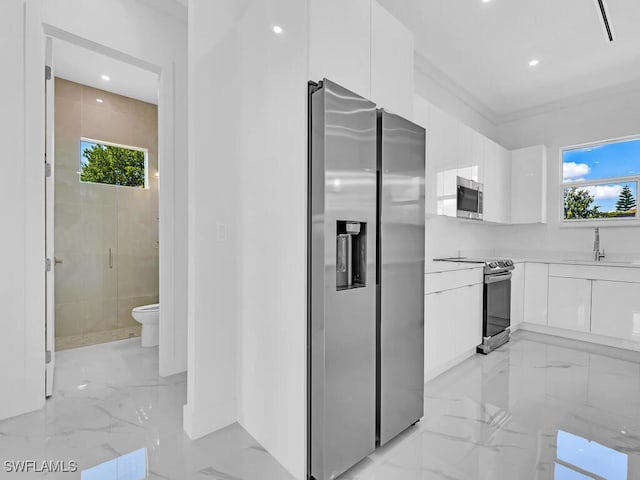 kitchen featuring plenty of natural light, white cabinetry, sink, and stainless steel appliances