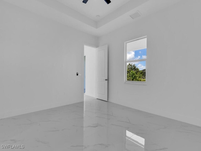 spare room with a tray ceiling