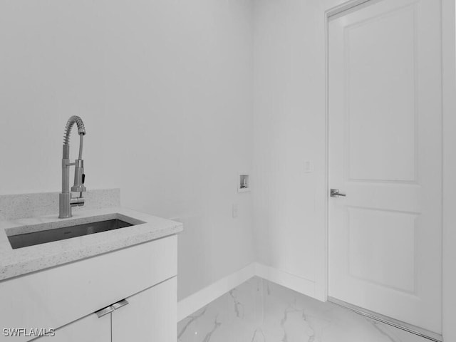 laundry area with cabinets, hookup for a washing machine, and sink