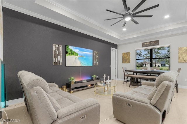 living room featuring ornamental molding, ceiling fan, and a tray ceiling