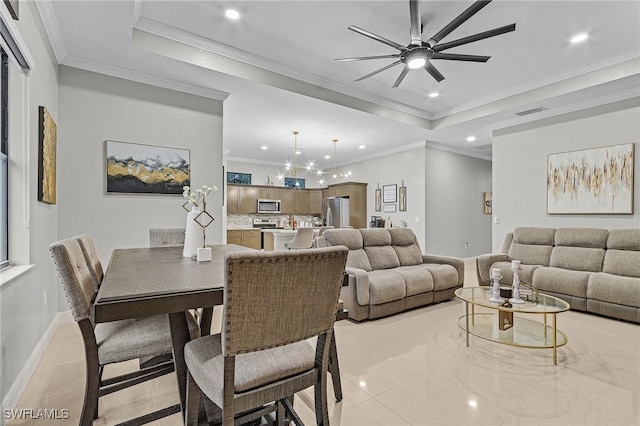 dining space featuring ornamental molding, light tile patterned flooring, ceiling fan, and a tray ceiling