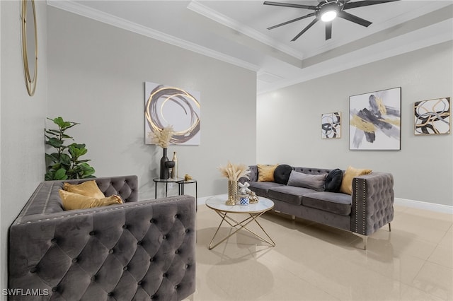 living room with ceiling fan, a tray ceiling, and ornamental molding