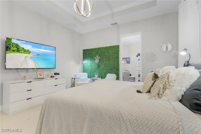 bedroom with a chandelier and a raised ceiling