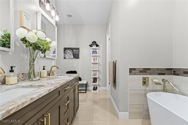 bathroom with vanity, tile patterned floors, and a washtub