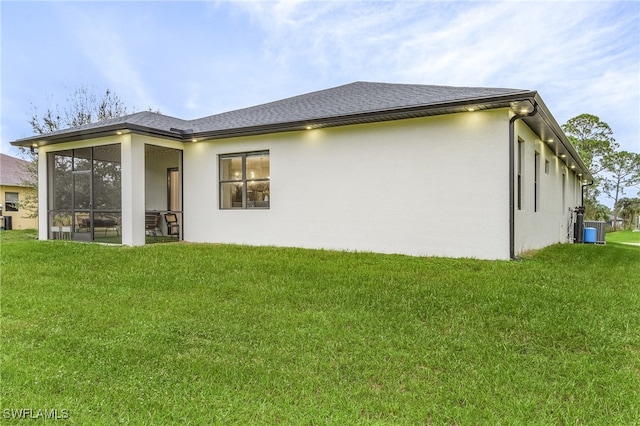 back of property with central air condition unit, a sunroom, and a yard