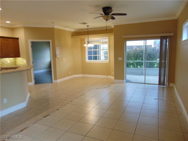 tiled spare room with ceiling fan with notable chandelier and crown molding