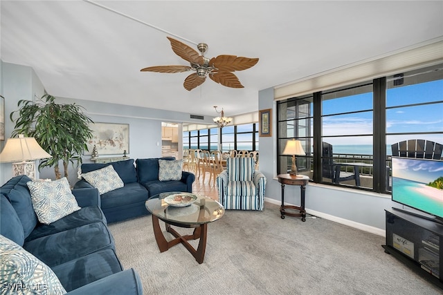 living room featuring ceiling fan with notable chandelier and carpet floors