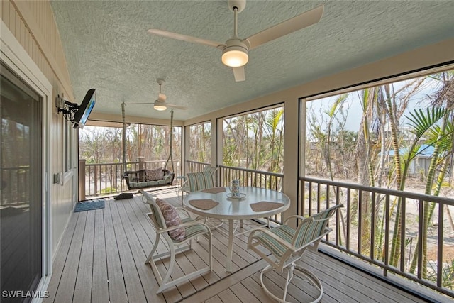 unfurnished sunroom featuring ceiling fan