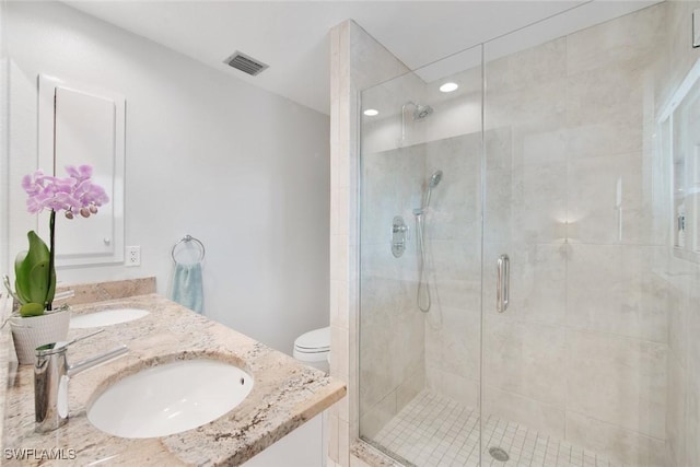 bathroom with an enclosed shower, vanity, and toilet