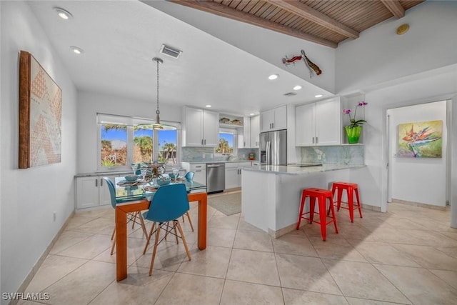 kitchen featuring white cabinetry, wood ceiling, stainless steel appliances, pendant lighting, and beamed ceiling