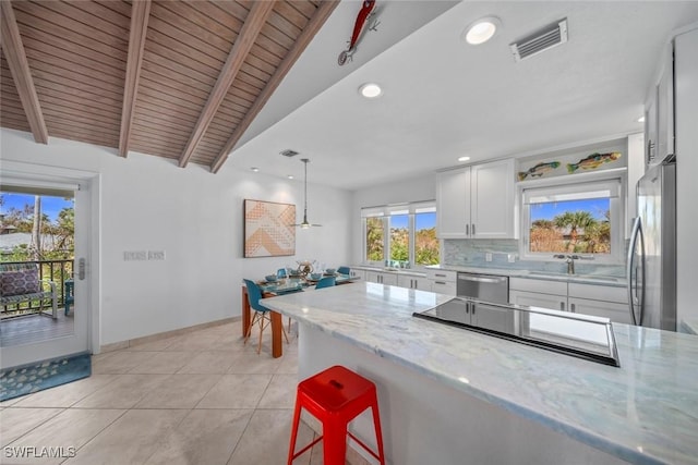 kitchen featuring wood ceiling, appliances with stainless steel finishes, light stone countertops, pendant lighting, and white cabinets