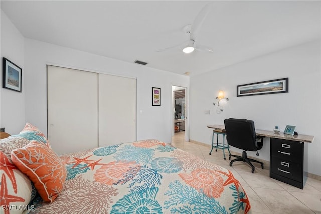 bedroom with ceiling fan, light tile patterned floors, and a closet