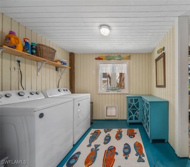 washroom featuring washer and dryer and wood walls