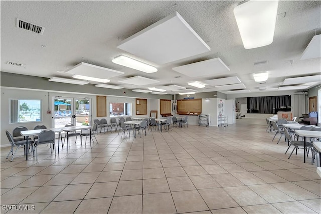 dining space with light tile patterned floors, a textured ceiling, and french doors