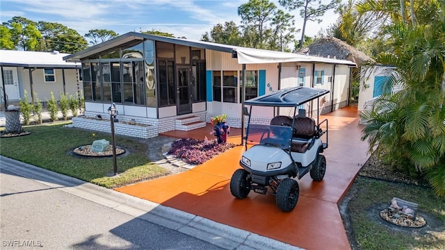 view of front of property featuring a front yard and a sunroom