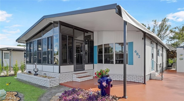 rear view of house featuring a sunroom