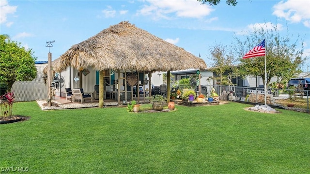 rear view of house featuring a gazebo, a lawn, and a patio