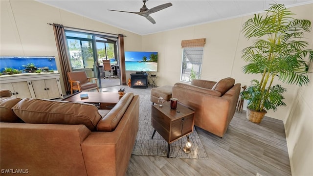 living room featuring crown molding, light wood-type flooring, and ceiling fan