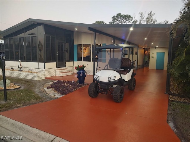 view of patio / terrace with a carport and a sunroom