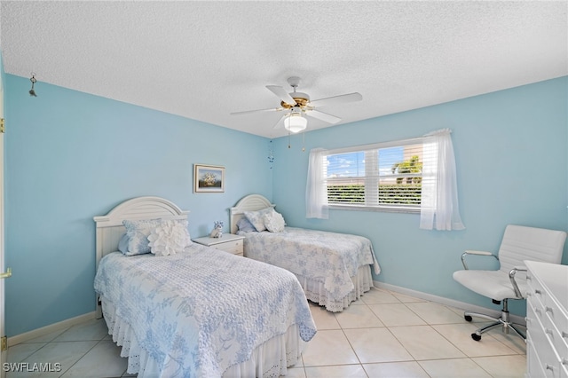 bedroom with a textured ceiling, ceiling fan, and light tile patterned flooring