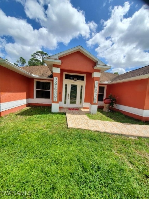 rear view of property with a lawn