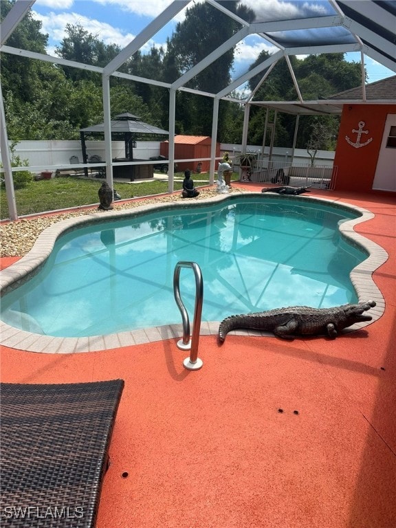 view of pool with glass enclosure and a patio