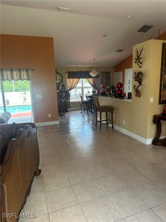 interior space with light tile patterned floors and vaulted ceiling