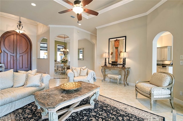 living room with ceiling fan with notable chandelier, light tile patterned floors, and crown molding