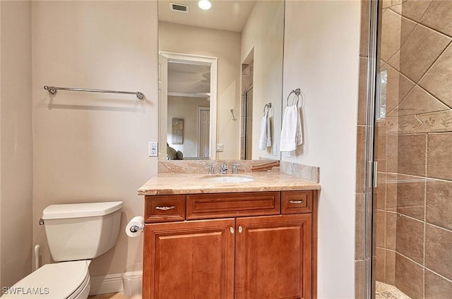 bathroom with vanity, toilet, an enclosed shower, and ornamental molding