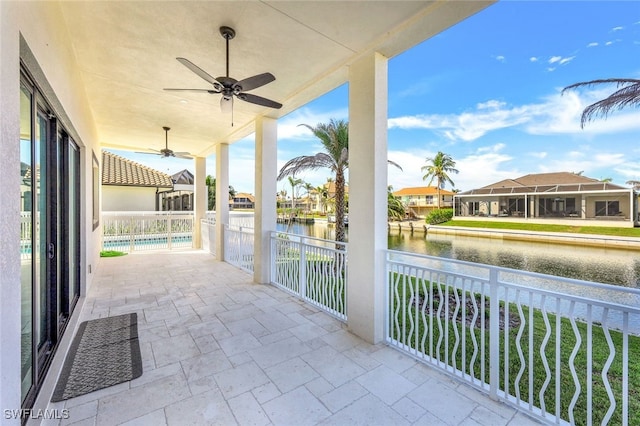 view of patio / terrace with a swimming pool, ceiling fan, and a water view