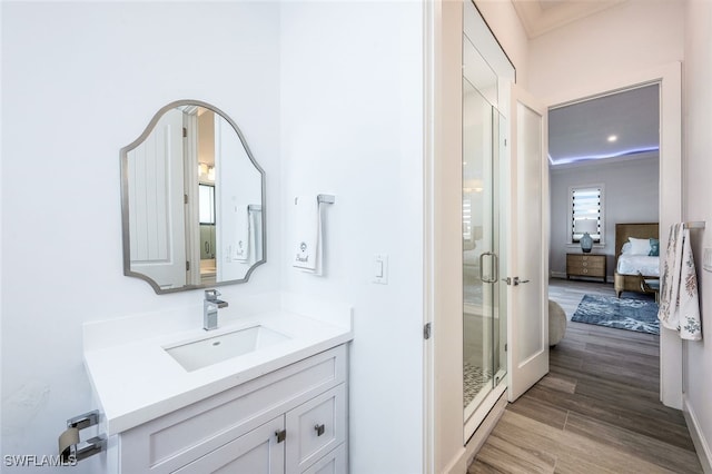 bathroom featuring vanity, hardwood / wood-style floors, and a shower with shower door